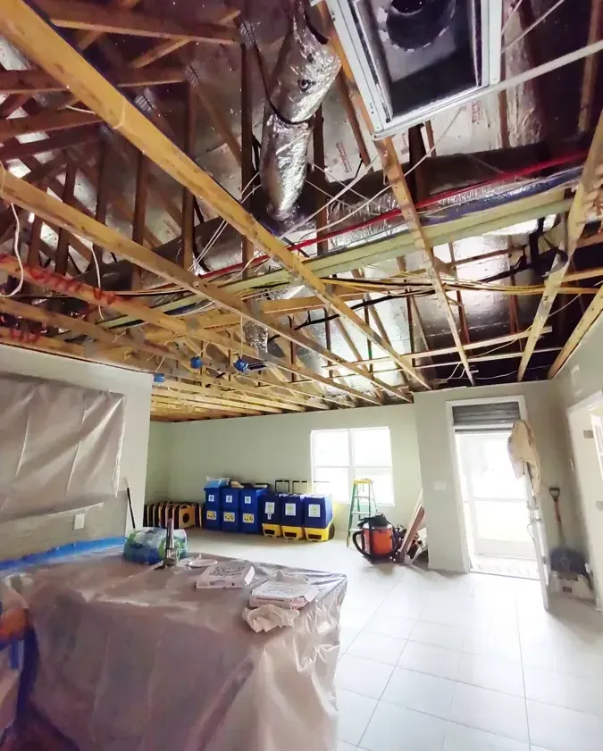 Opened overhead framing with plastic protection and drying equipment below