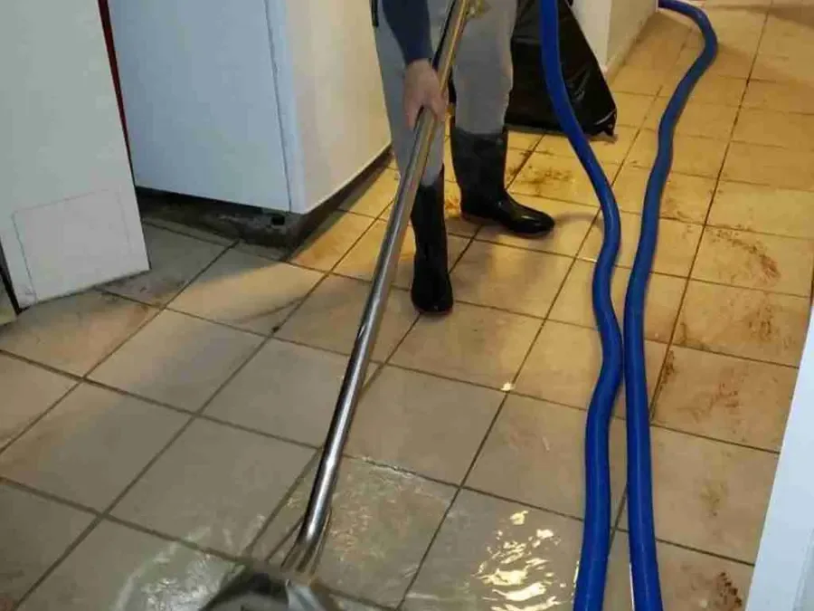 Extraction wand removing standing water from a tiled indoor floor